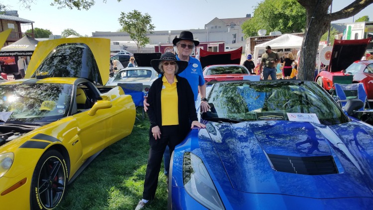 Two people standing beside their Corvette