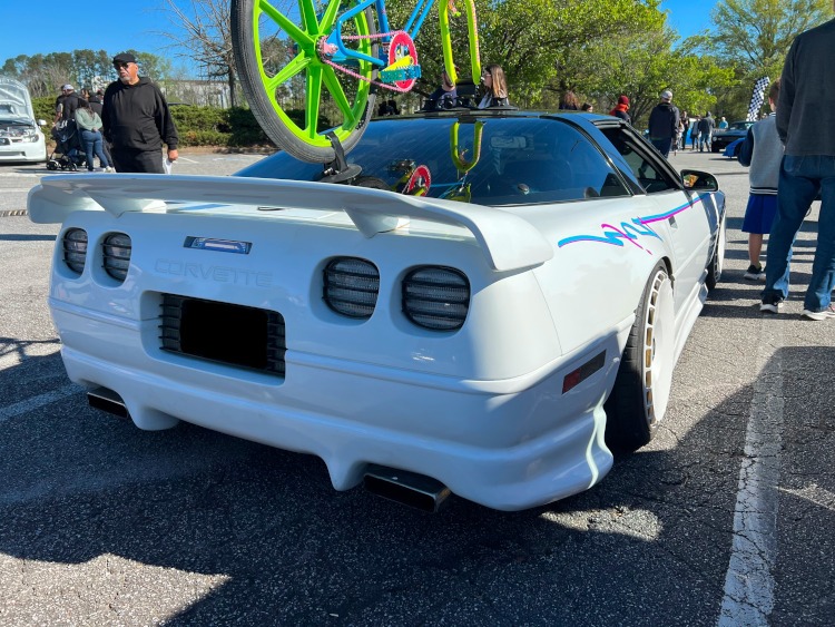 A custom white fourth-generation Corvette coupe at a car show.