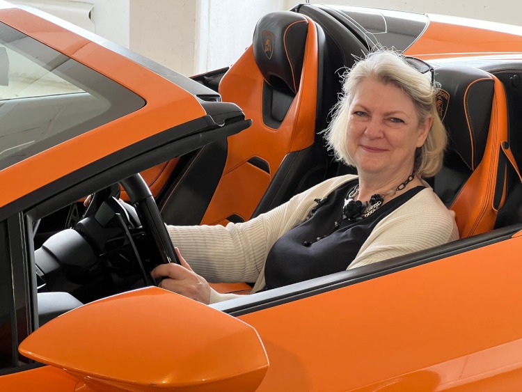 Woman sitting in the drivers side of an orange car
