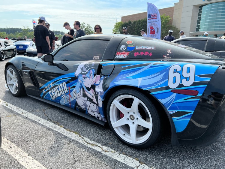 A Corvette with Asian letters on a wrap.