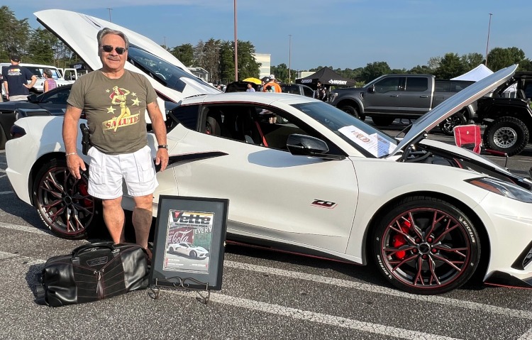 A man is standing beside a 70th-anniversary Corvette