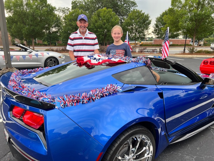 A blue Corvette coupe decorated for a 4th of July parade.