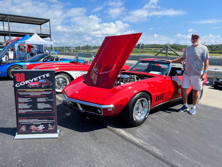 A red 1968 Corvette coupe at a car show.