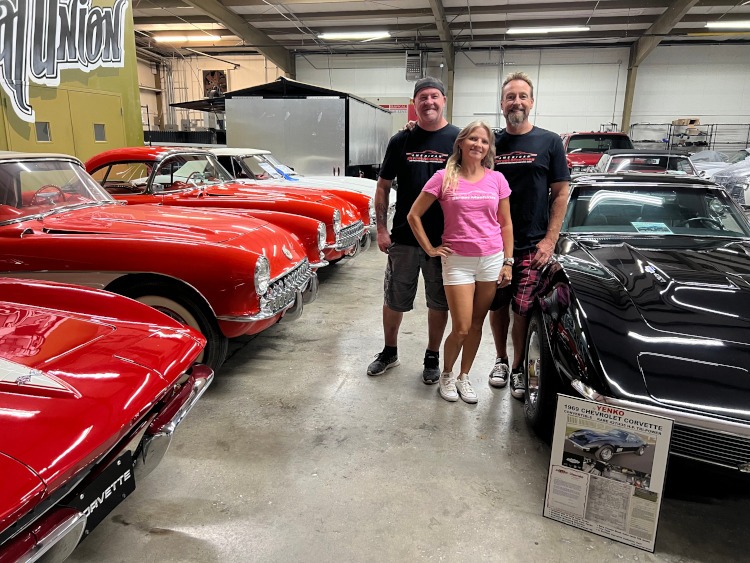 Three people from American Street Machines standing near classic Corvettes.
