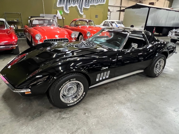 The side view of a black Classic Corvette coupe.