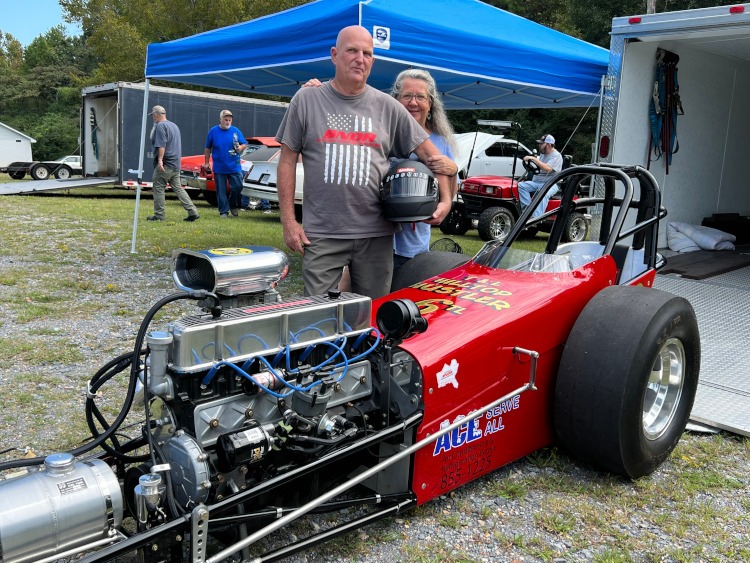 A red dragster at a car show.
