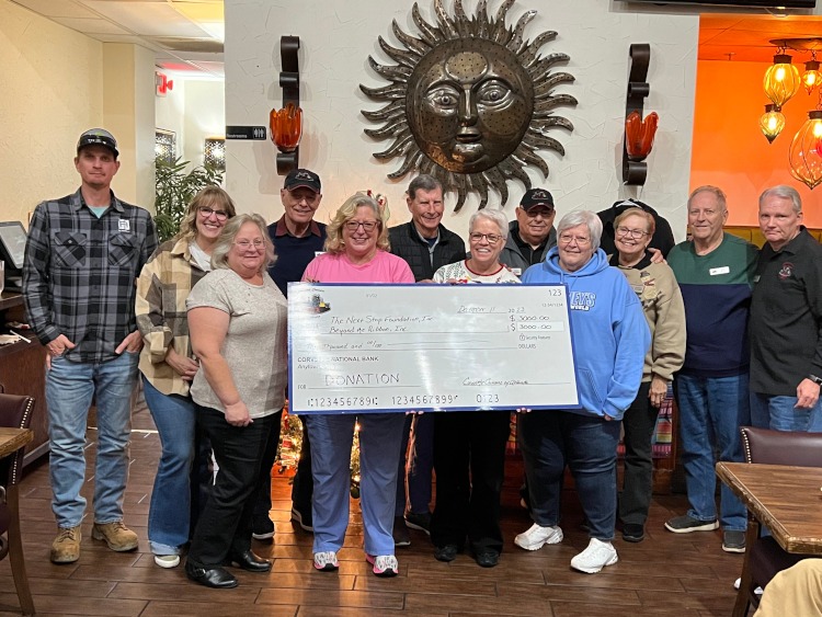 Two charities receive a large check.
