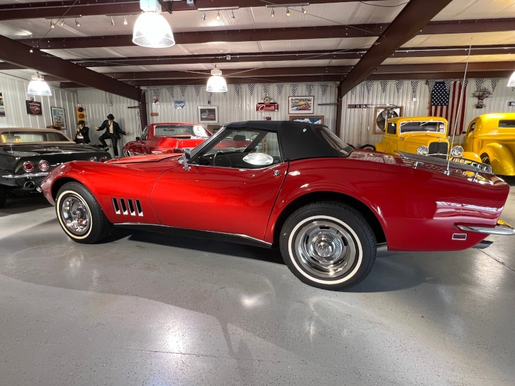 A red C3 Corvette coupe with a black top.