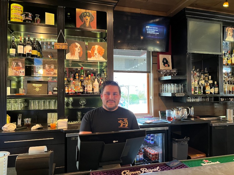 A manager behind the bar of a tavern.