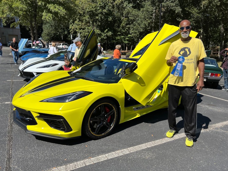 A man wins a blue ribbon for his 2022 yellow Corvette.
