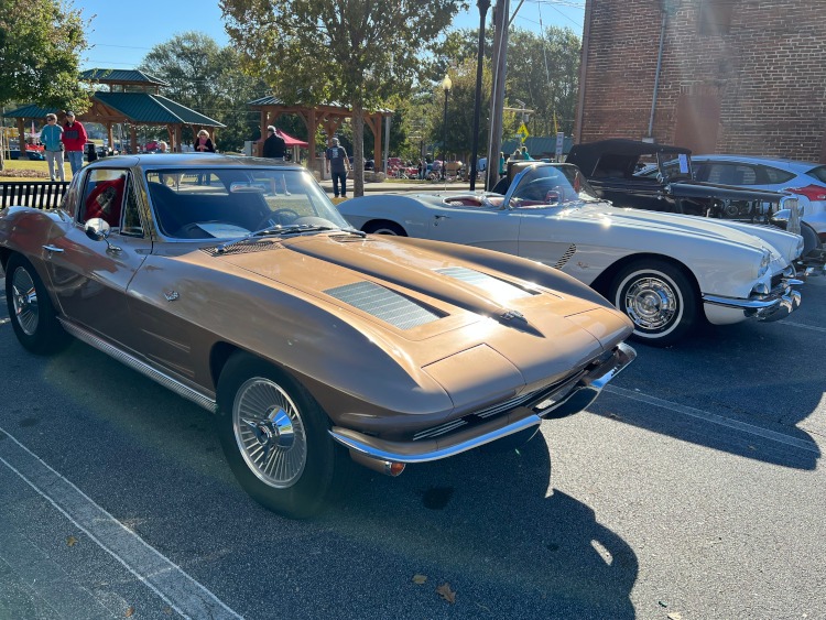 Two vintage Corvettes at a car show.