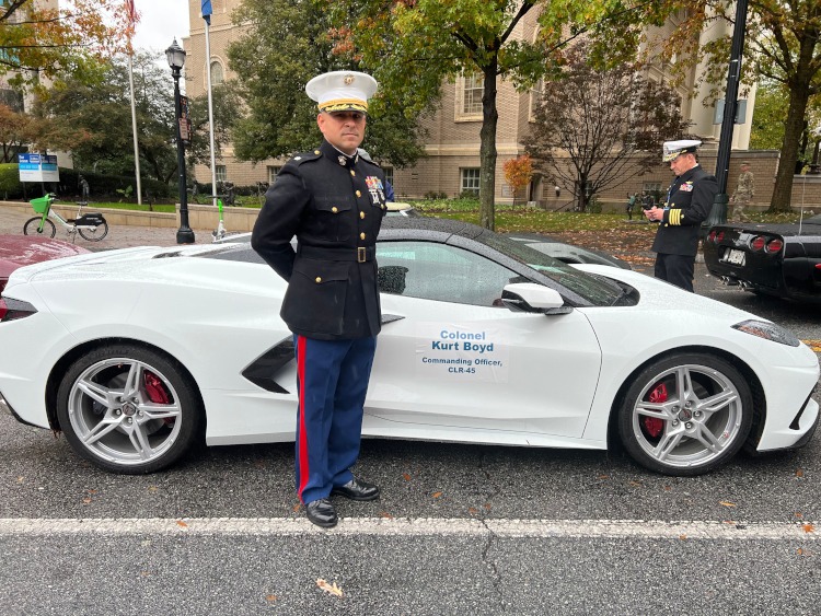 A Marine Colonel standing beside a C8 Corvette