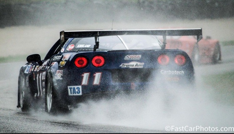 Rear view of a C6 racecar in the rain.