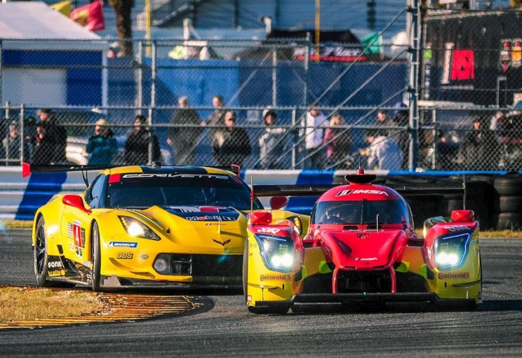 A yellow C8 Corvette race car pursuing another race car.