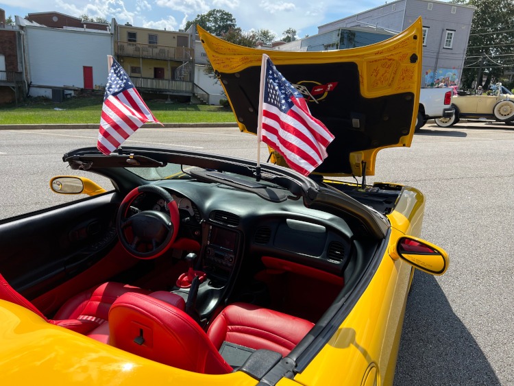 American flags on a yellow C5 Corvette convertible.