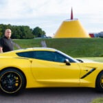 A man and his yellow Corvette.