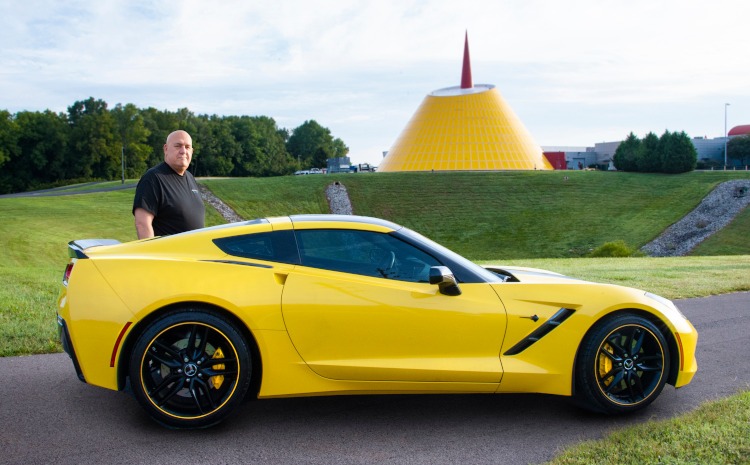 A man and his yellow Corvette.
