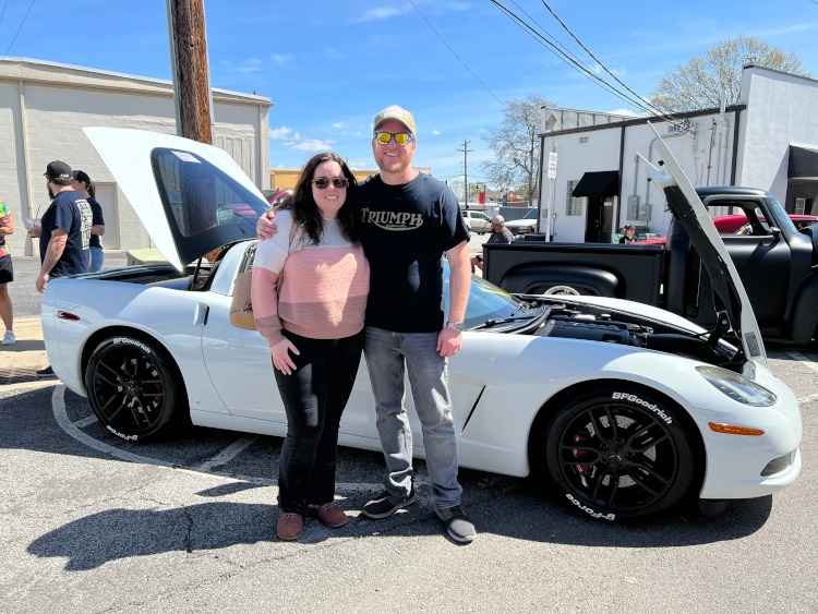 Two people standing beside a 2008 Corvette coupe